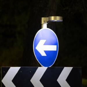 Type A Light Unit – UK traffic management LED safety light illuminating a directional road sign at night.