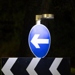 Type A Light Unit – UK traffic management LED safety light illuminating a directional road sign at night.